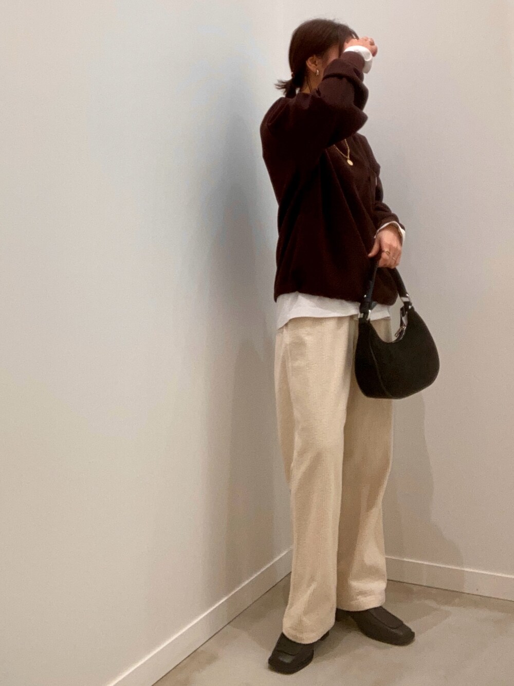 ブラウン系のスウェット、ホワイト系のその他パンツ、ブラック系のショルダーバッグを着用したレディースの冬コーディネートの4枚目の写真