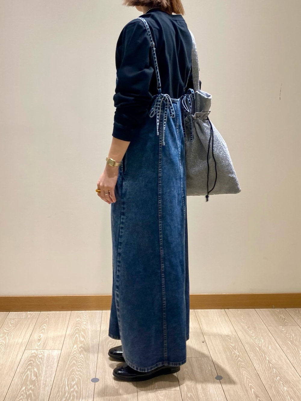 ブラック系のTシャツ/カットソー、ブルー系のワンピース、シルバー系のトートバッグを着用したレディースの秋コーディネートの5枚目の写真