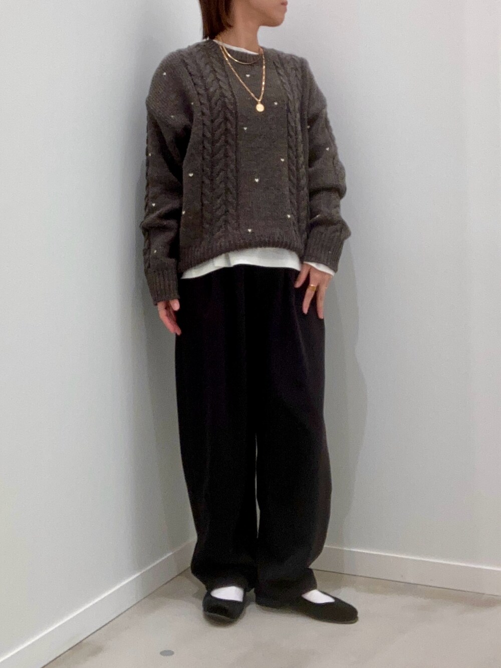 グレー系のニット/セーター、ホワイト系のTシャツ/カットソー、ブラック系のその他パンツを着用したレディースの秋コーディネートの2枚目の写真