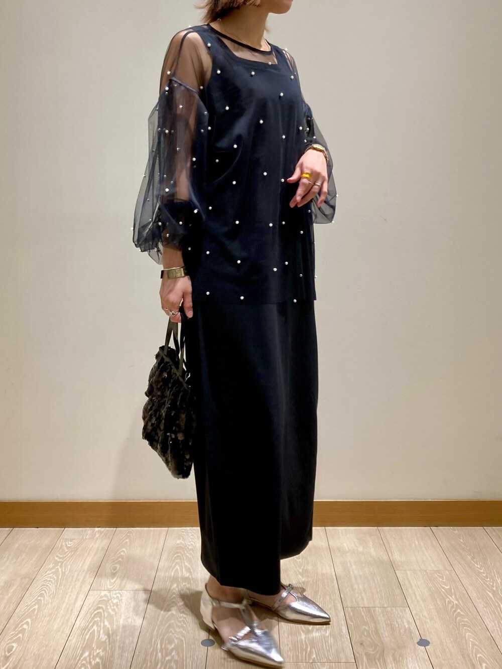 ブラック系のワンピース、ブラック系のTシャツ/カットソー、ブラック系のハンドバッグを着用したレディースの秋コーディネートの2枚目の写真