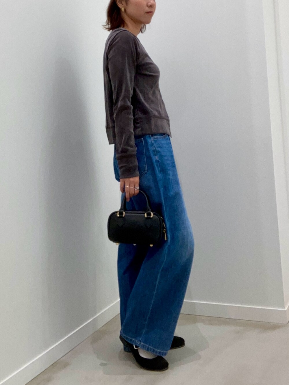 グレー系のカーディガン/ボレロ、ブルー系のデニムパンツ、ブラック系のショルダーバッグを着用したレディースの秋コーディネートの3枚目の写真