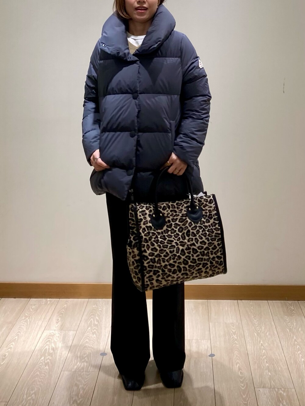 ブラック系のその他パンツ、グレー系のダウンジャケット/コート、イエロー系のニット/セーターを着用したレディースの冬コーディネートの9枚目の写真