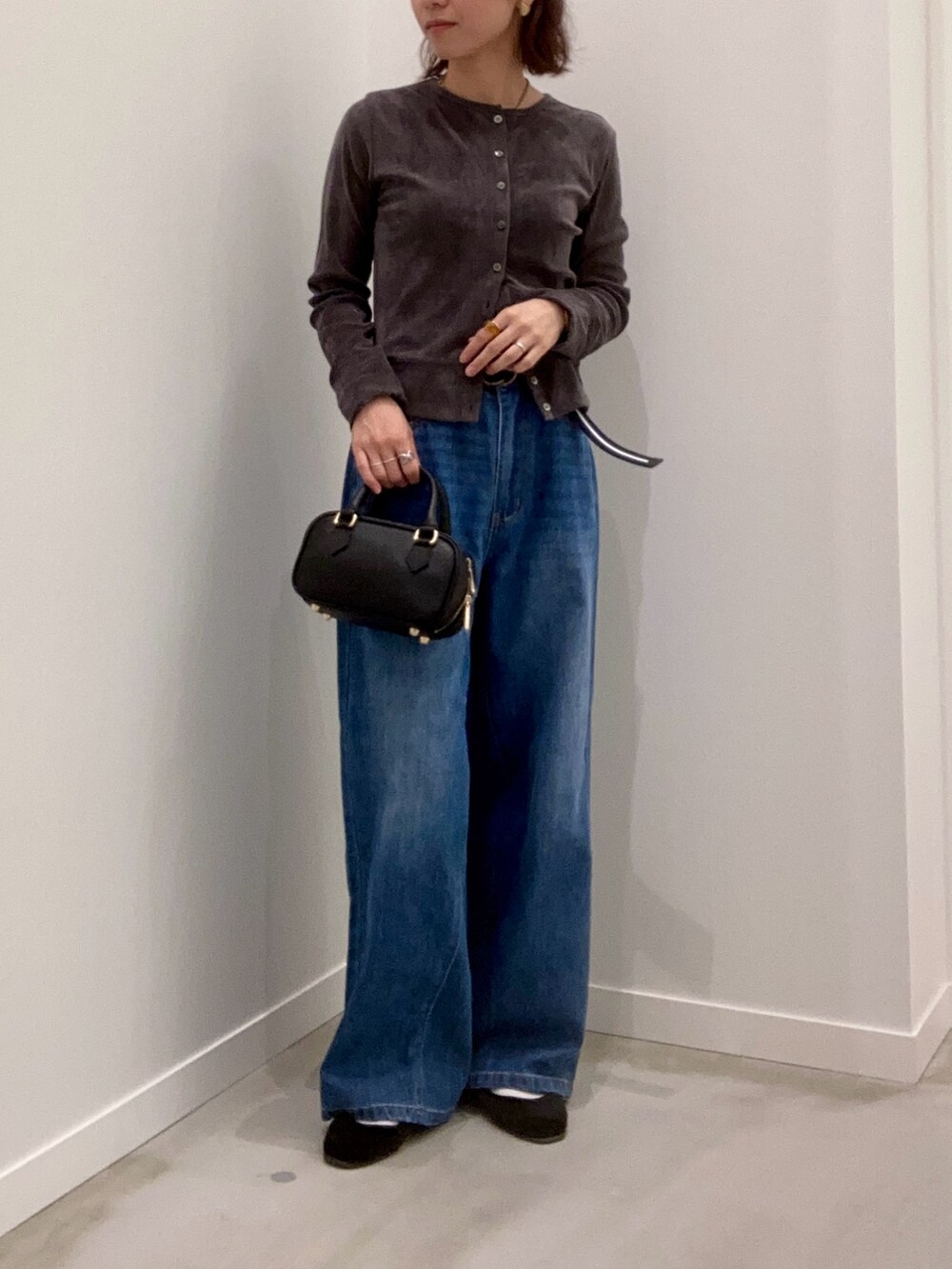 グレー系のカーディガン/ボレロ、ブルー系のデニムパンツ、ブラック系のショルダーバッグを着用したレディースの秋コーディネートの8枚目の写真