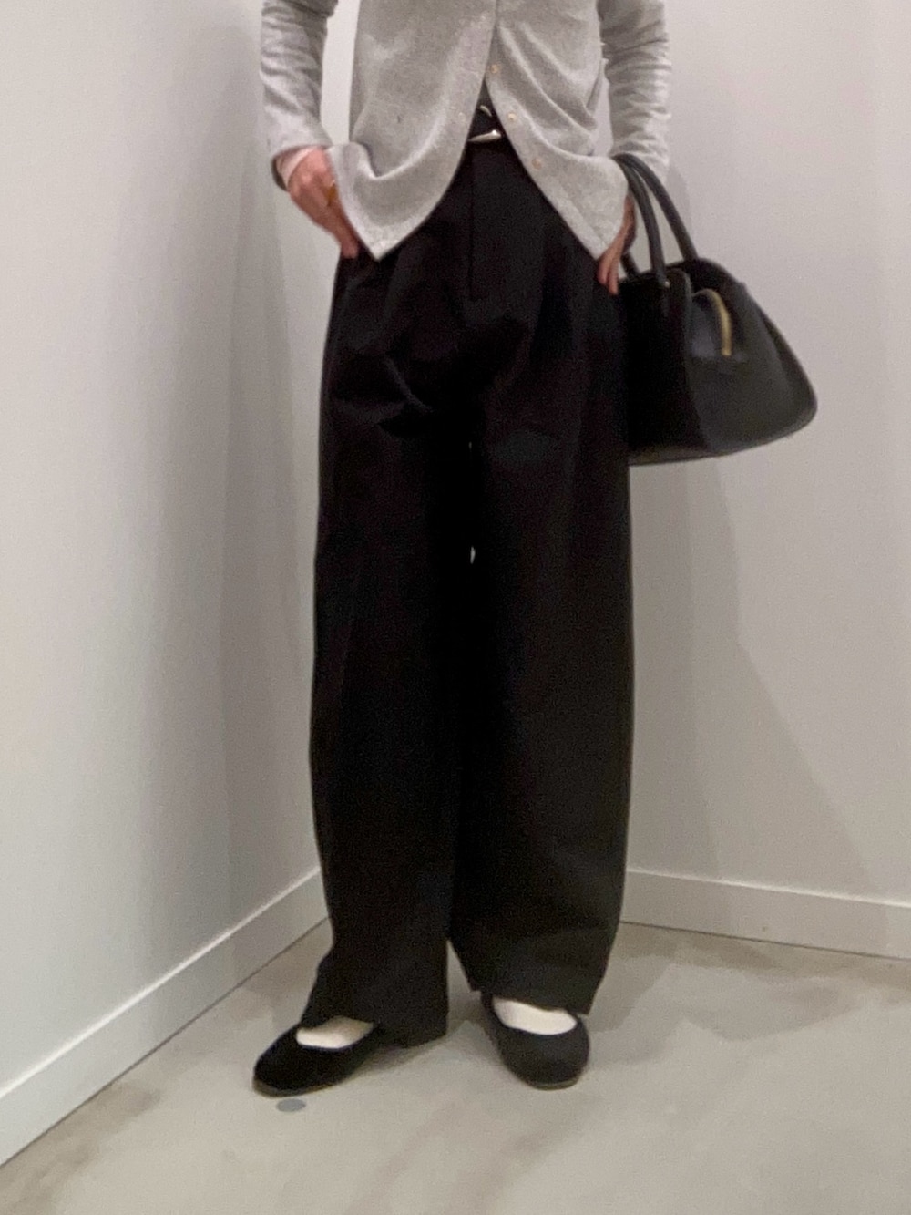 グレー系のカーディガン/ボレロ、グレー系のTシャツ/カットソー、ブラック系のチノパンツを着用したレディースの冬コーディネートの4枚目の写真