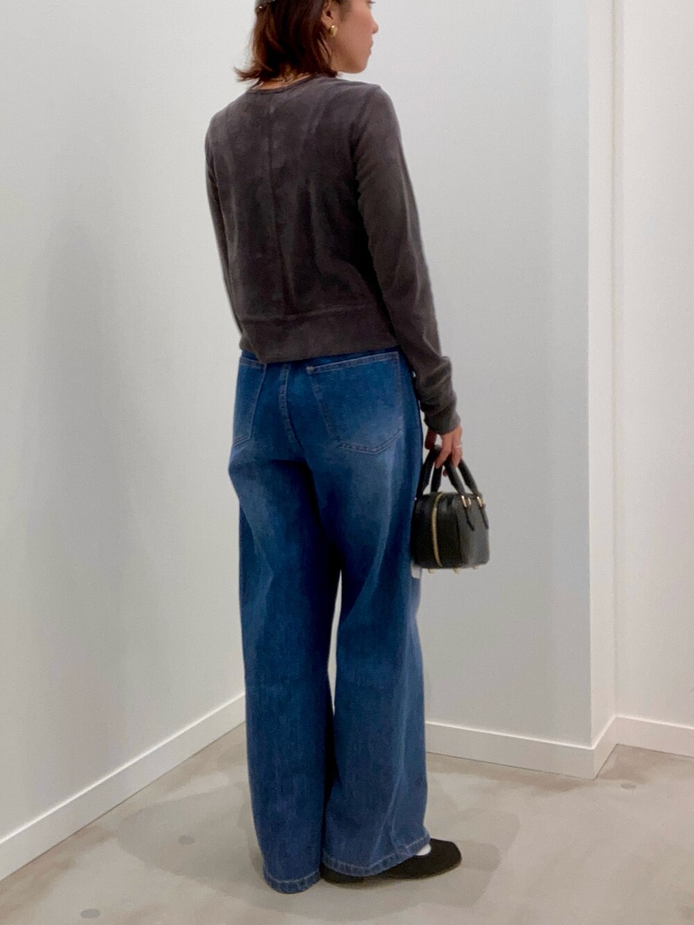 グレー系のカーディガン/ボレロ、ブルー系のデニムパンツ、ブラック系のショルダーバッグを着用したレディースの秋コーディネートの4枚目の写真