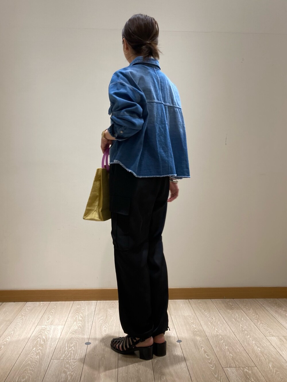 ブラック系のその他パンツ、イエロー系のかごバッグ、ブルー系のシャツ/ブラウスを着用したレディースの春コーディネートの4枚目の写真