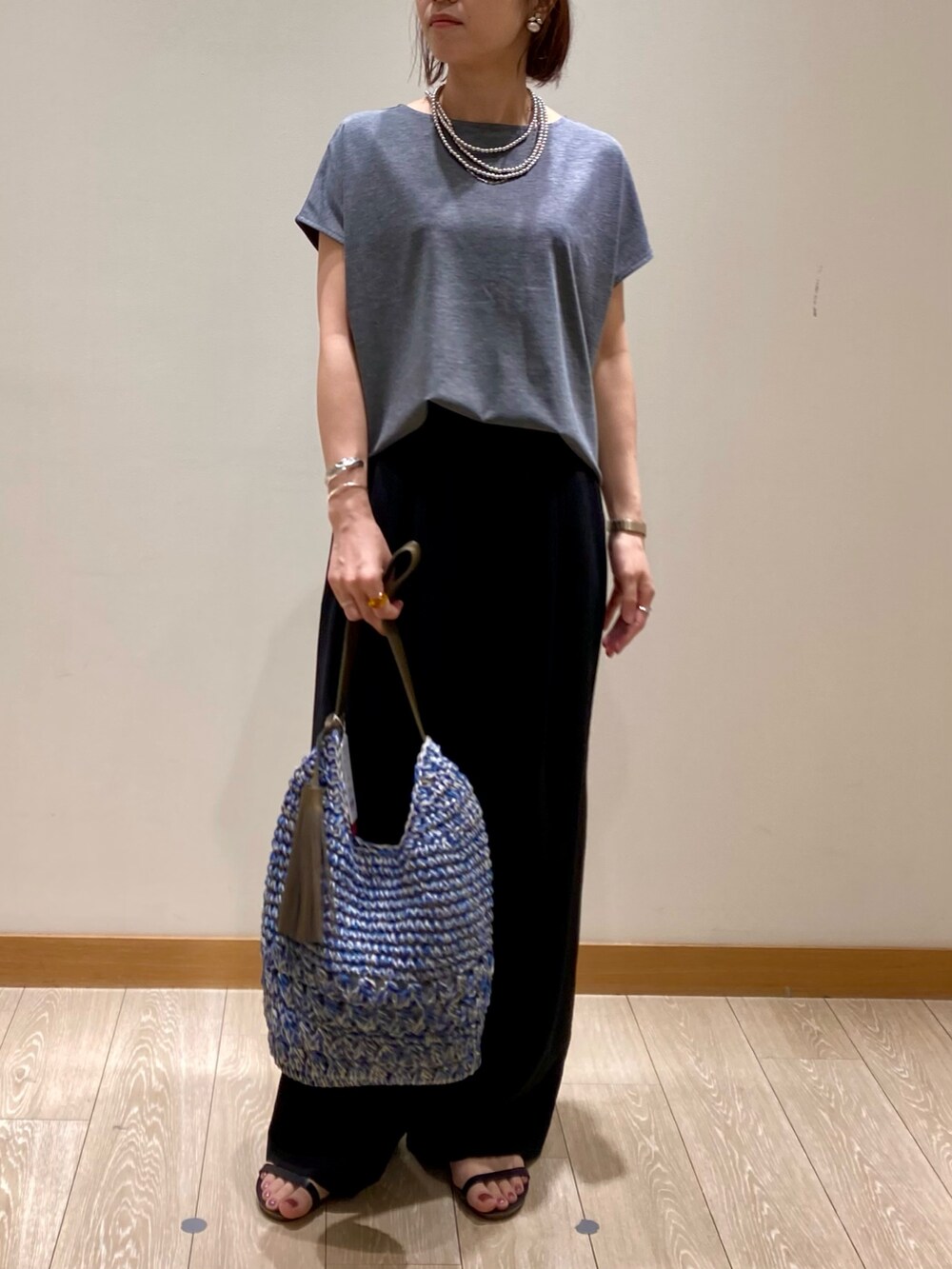 グレー系のTシャツ/カットソー、ブルー系のかごバッグ、ブラック系のその他パンツを着用したレディースの夏コーディネートの2枚目の写真