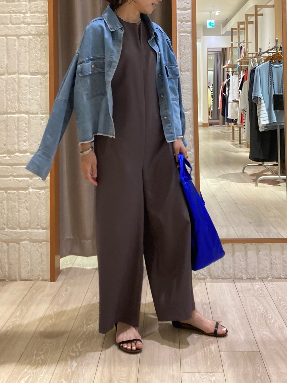ブラウン系のつなぎ/オールインワン、ブラック系のサンダル、ブルー系のシャツ/ブラウスを着用したレディースの夏コーディネートの3枚目の写真