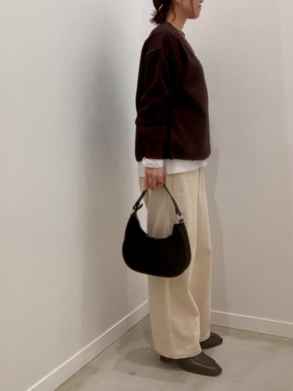 ブラウン系のスウェット、ホワイト系のその他パンツ、ブラック系のショルダーバッグを着用したレディースの冬コーディネートの5枚目の写真