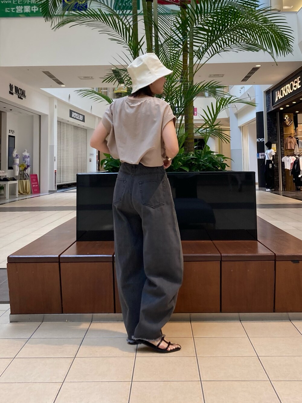 ブラック系のデニムパンツ、ブラック系のサンダル、ブラック系のトートバッグを着用したレディースの春コーディネートの3枚目の写真