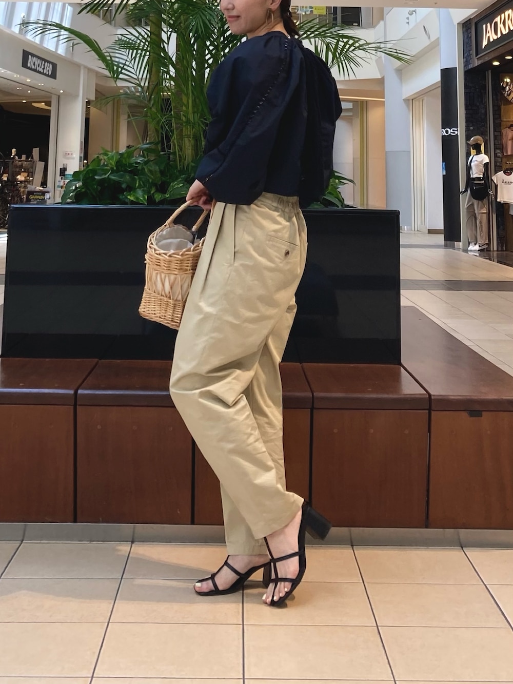 ブラック系のシャツ/ブラウス、ベージュ系のその他パンツ、ベージュ系のかごバッグを着用したレディースの春コーディネートの2枚目の写真