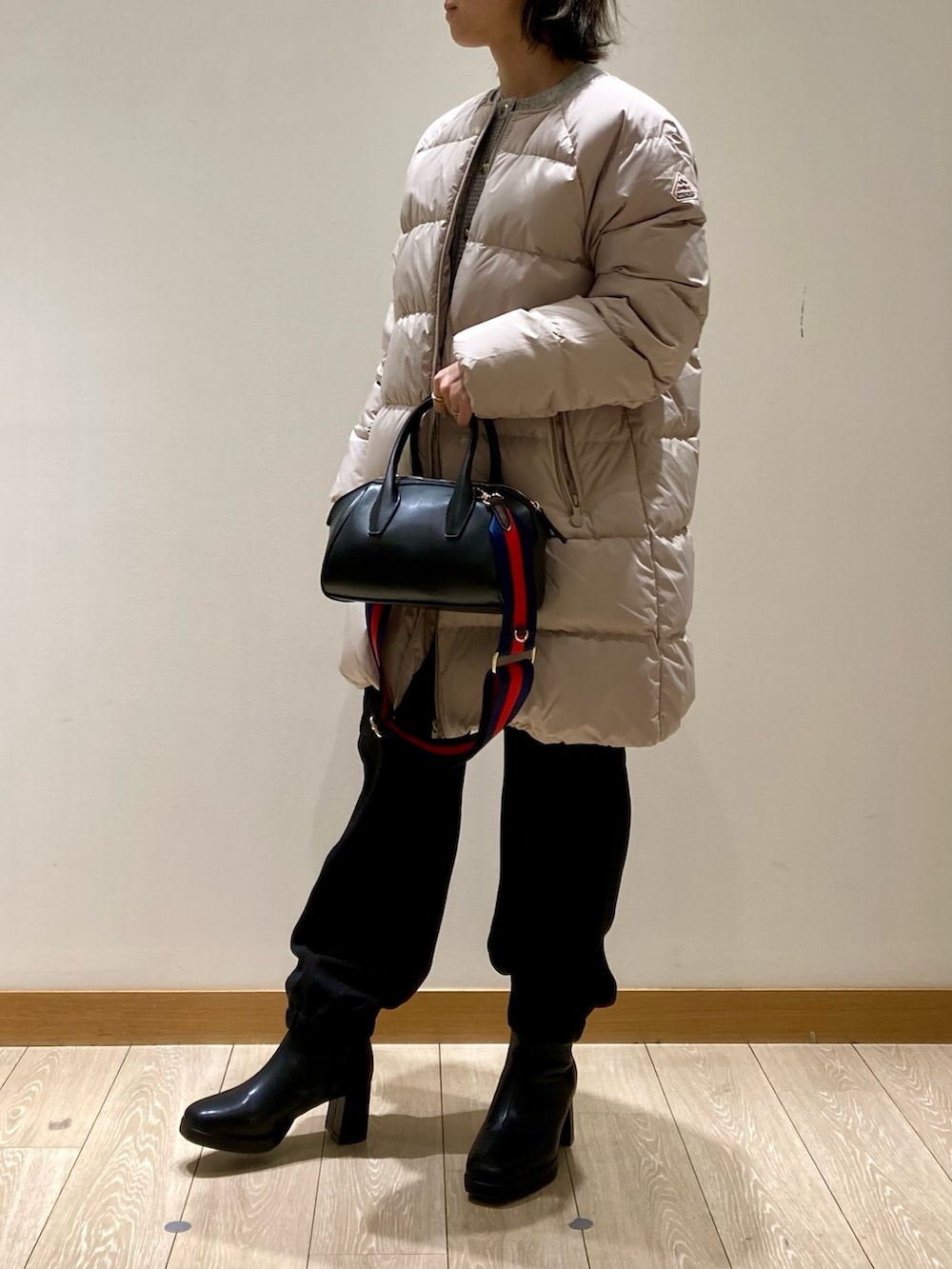 ベージュ系のダウンジャケット/コート、ブラック系のカーゴパンツ、ブラック系のブーツを着用したレディースの冬コーディネートの2枚目の写真