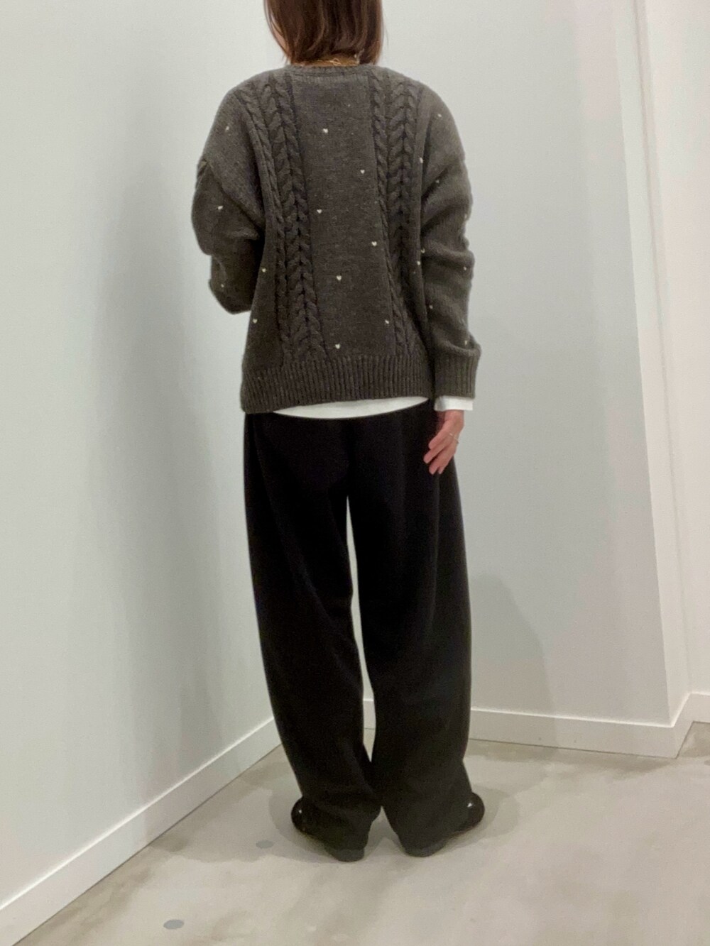 グレー系のニット/セーター、ホワイト系のTシャツ/カットソー、ブラック系のその他パンツを着用したレディースの秋コーディネートの5枚目の写真