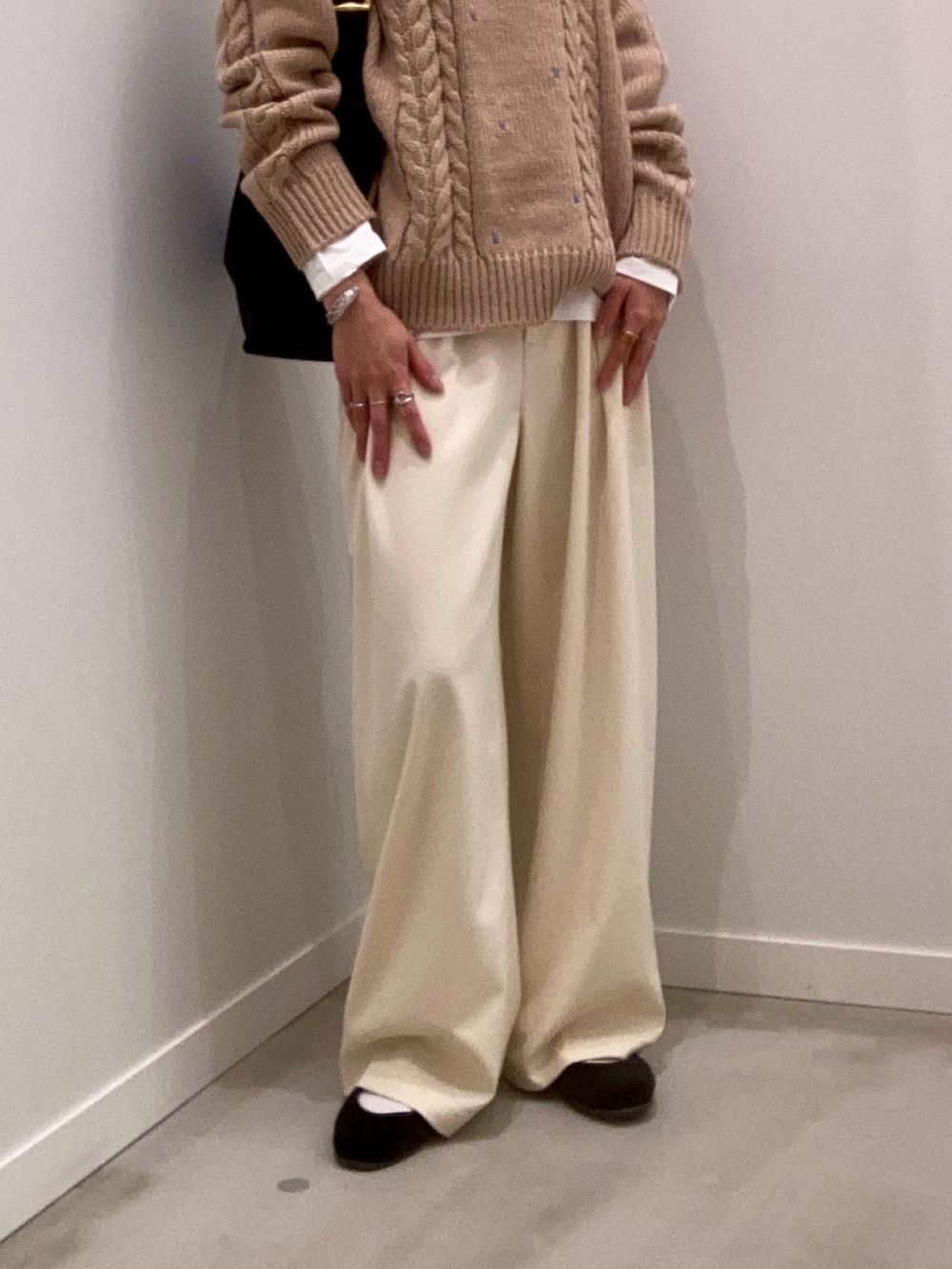 ベージュ系のニット/セーター、ホワイト系のTシャツ/カットソー、ブラック系のショルダーバッグを着用したレディースの秋コーディネートの9枚目の写真