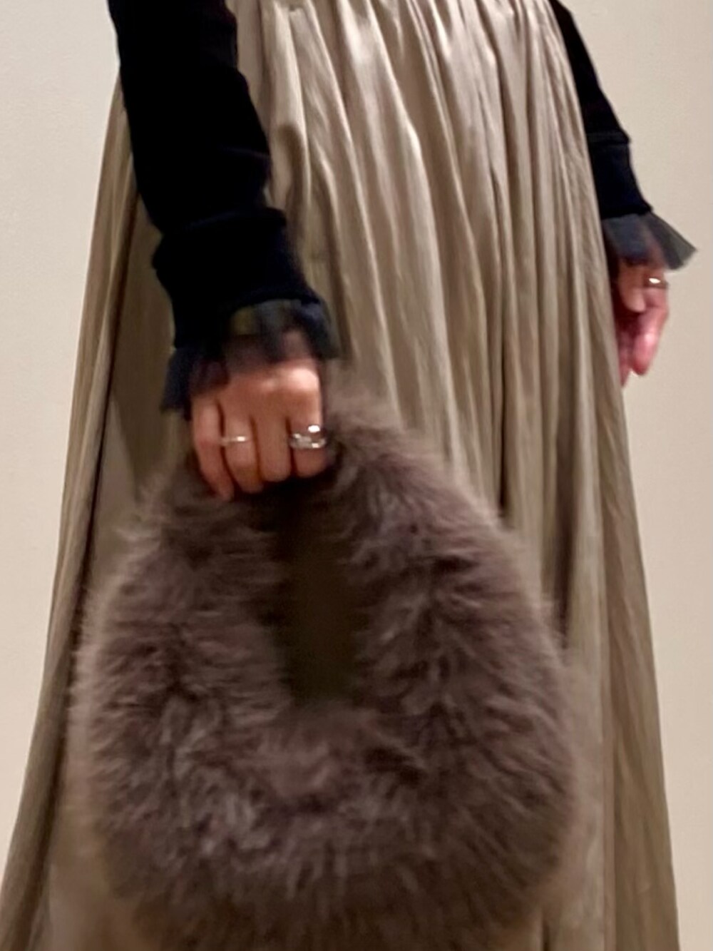 グレー系のハンドバッグ、ブラック系のブーツ、ブラック系のTシャツ/カットソーを着用したレディースの秋コーディネートの9枚目の写真