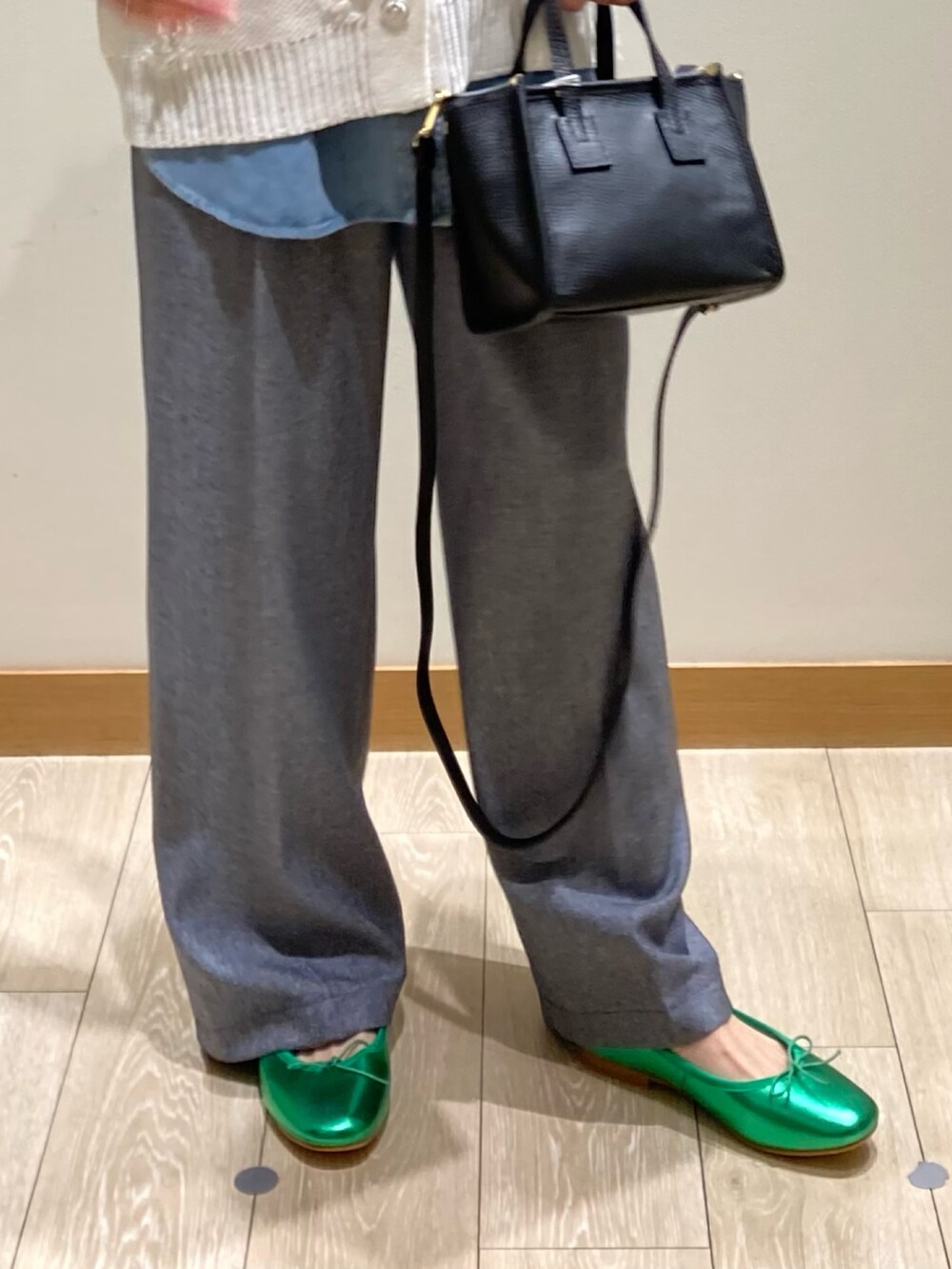 ブラック系のトートバッグ、ブルー系のスラックス、グリーン系のバレエシューズを着用したレディースの冬コーディネートの10枚目の写真