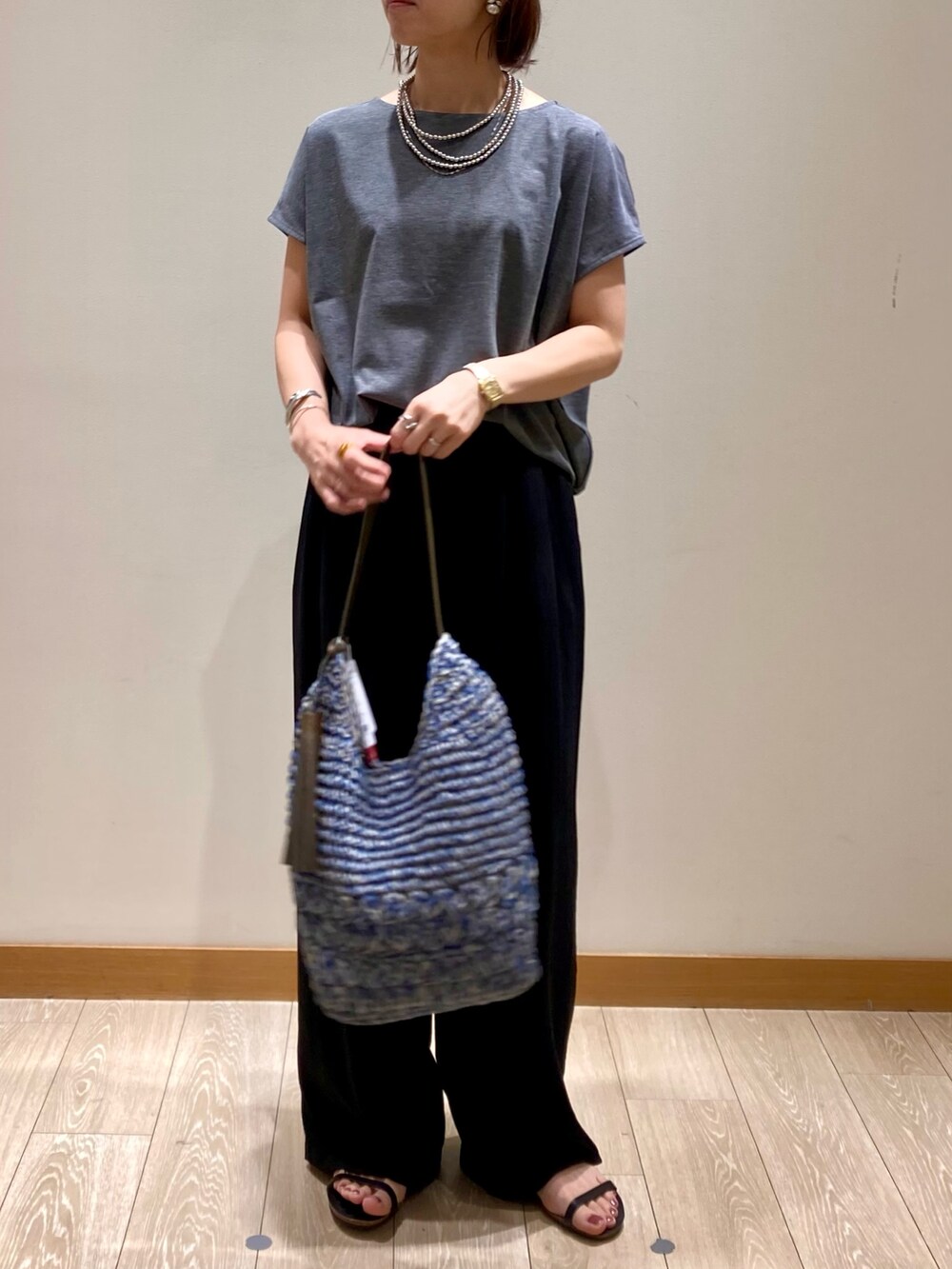 グレー系のTシャツ/カットソー、ブルー系のかごバッグ、ブラック系のその他パンツを着用したレディースの夏コーディネートの8枚目の写真