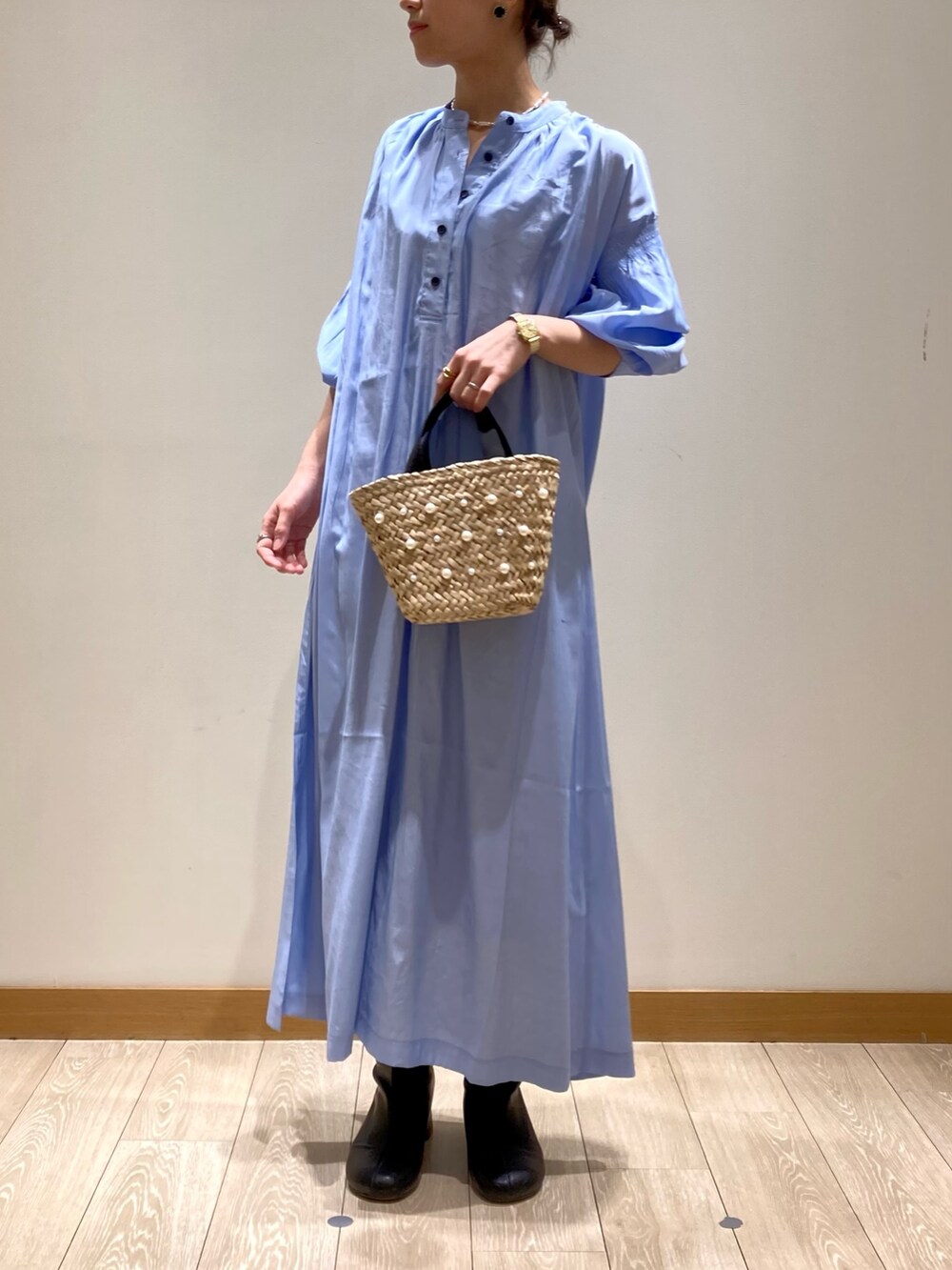 ブルー系のワンピース、ホワイト系のトートバッグ、ゴールド系のネックレスを着用したレディースの春コーディネートの2枚目の写真