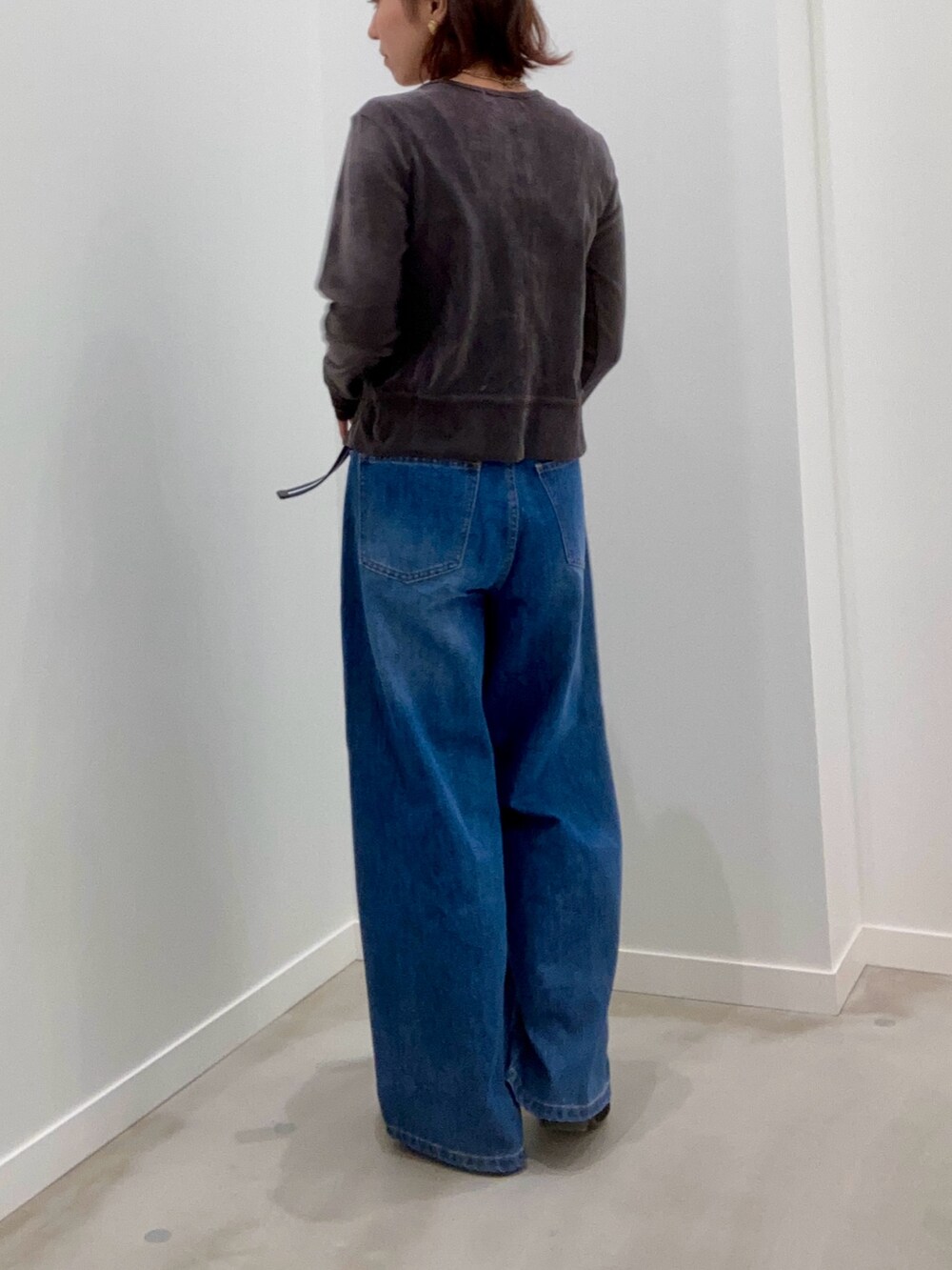 グレー系のカーディガン/ボレロ、ブルー系のデニムパンツ、ブラック系のショルダーバッグを着用したレディースの秋コーディネートの6枚目の写真