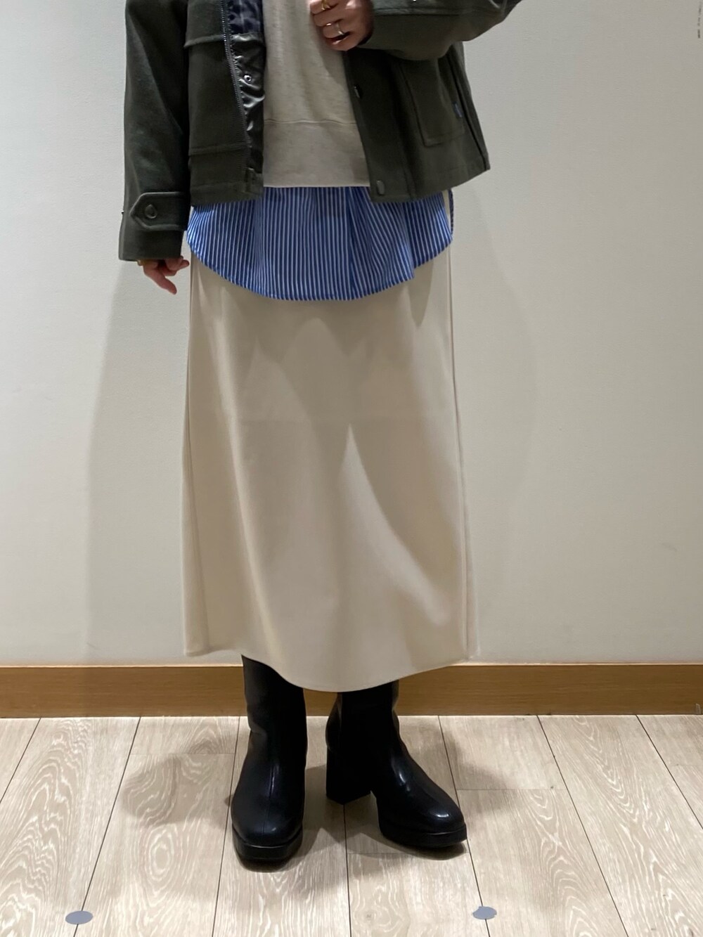 グリーン系のテーラードジャケット、グレー系のスウェット、ホワイト系のスカートを着用したレディースの冬コーディネートの4枚目の写真