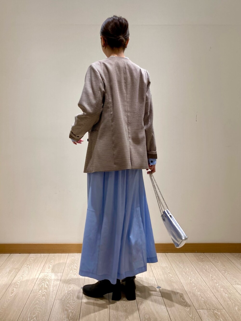 シルバー系のショルダーバッグ、ブルー系のワンピース、ベージュ系のノーカラージャケットを着用したレディースの春コーディネートの6枚目の写真