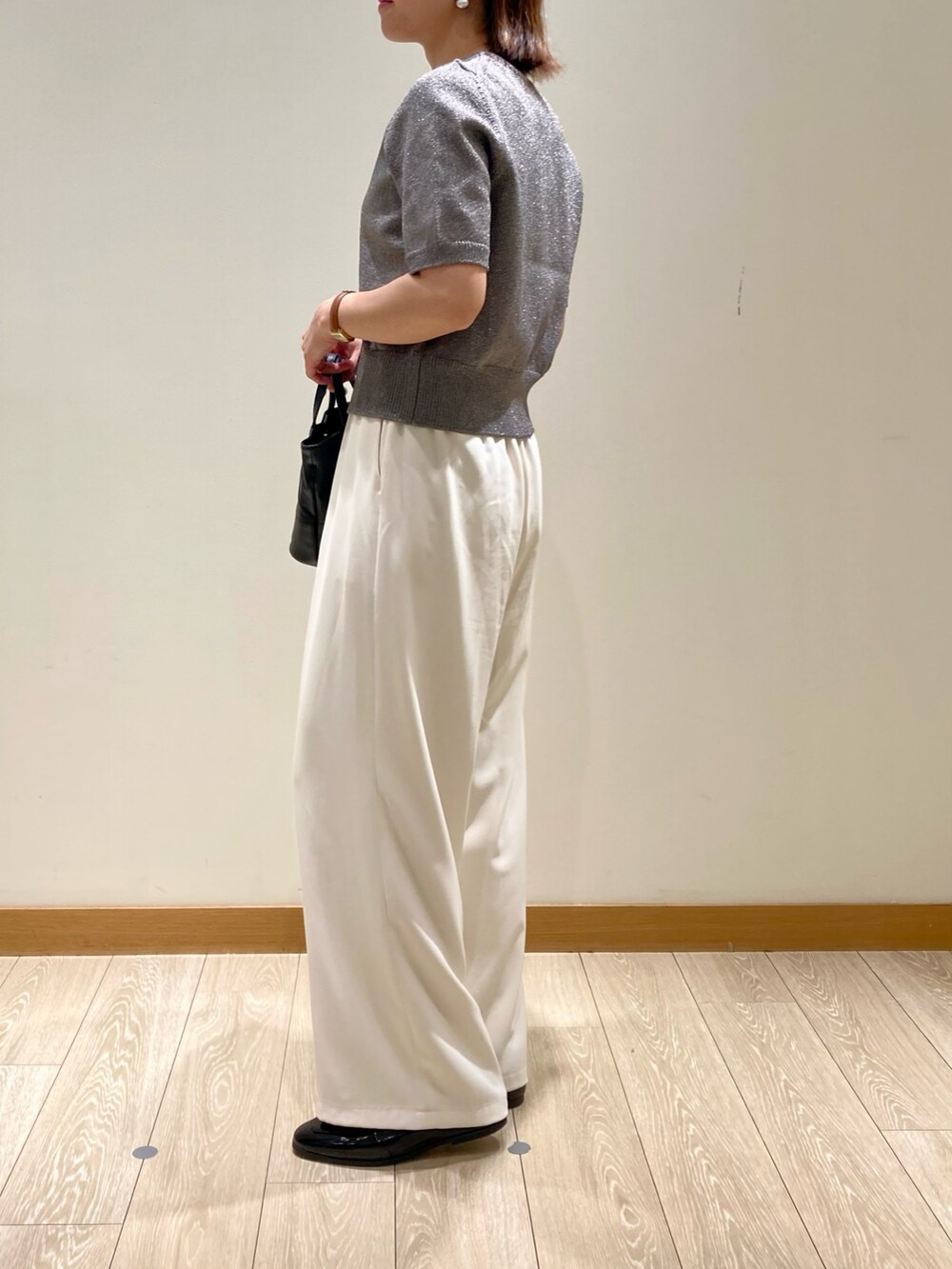 ホワイト系のその他パンツ、ブラック系のショルダーバッグ、グレー系のニット/セーターを着用したレディースの秋コーディネートの6枚目の写真