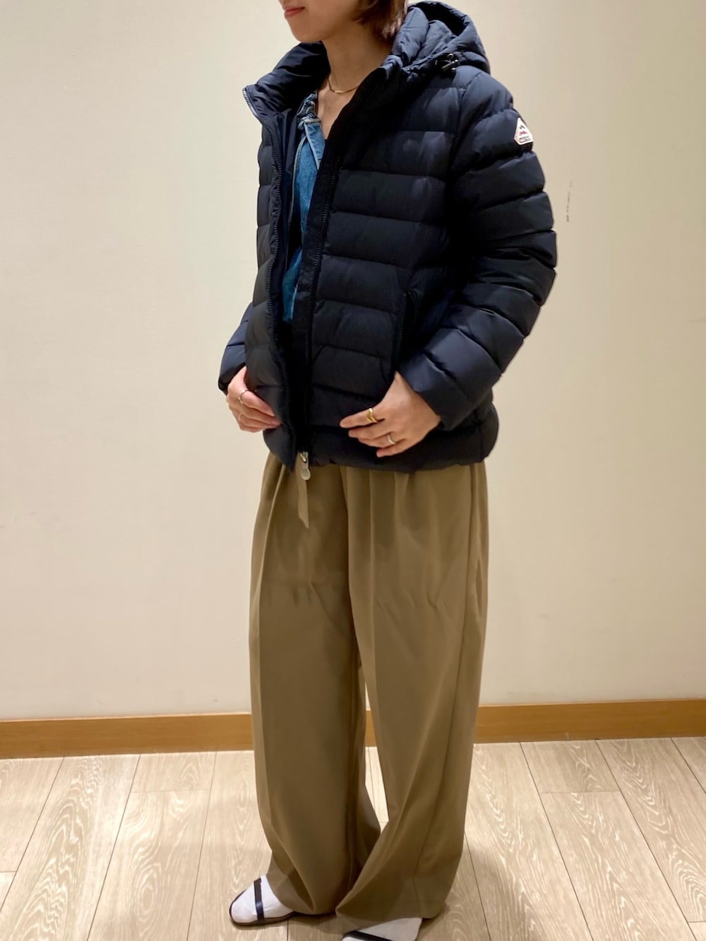 ブラック系のダウンジャケット/コート、ブルー系のシャツ/ブラウスを着用したレディースの秋コーディネートの2枚目の写真