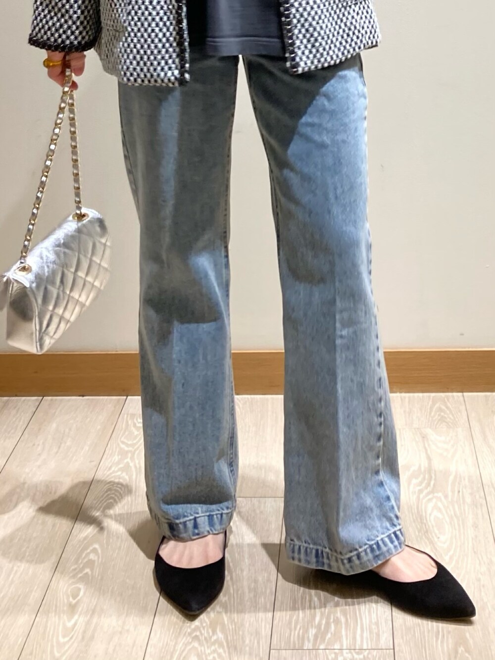 ブルー系のデニムパンツ、シルバー系のショルダーバッグ、ブラック系のノーカラージャケットを着用したレディースの冬コーディネートの8枚目の写真