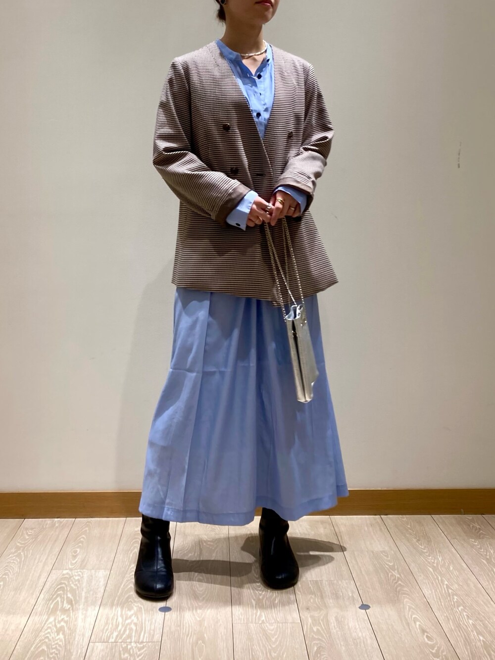 シルバー系のショルダーバッグ、ブルー系のワンピース、ベージュ系のノーカラージャケットを着用したレディースの春コーディネートの2枚目の写真