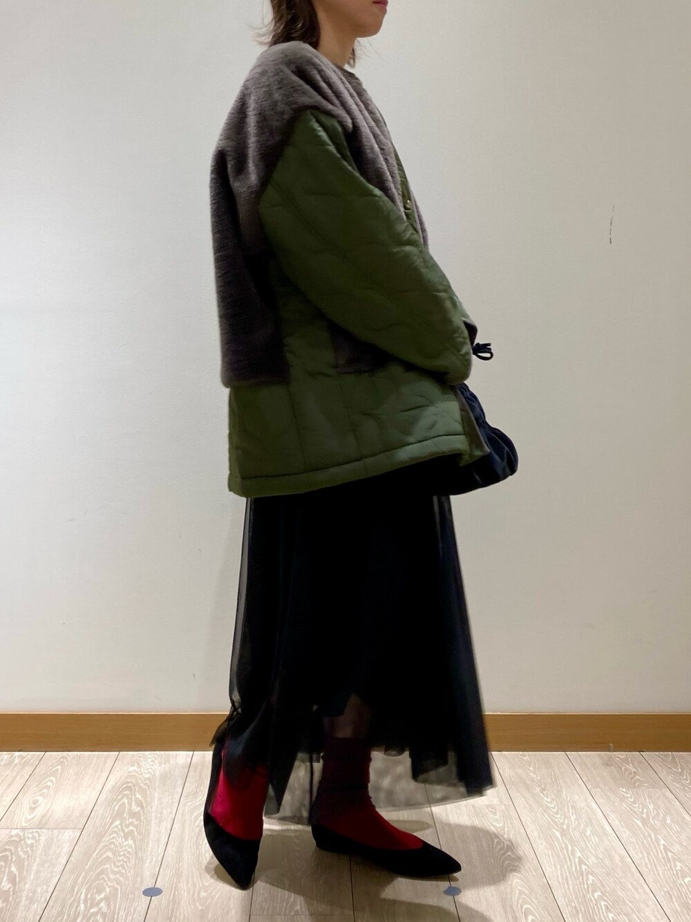 ブラック系のショルダーバッグ、ブラック系のワンピース、グリーン系のブルゾンを着用したレディースの冬コーディネートの6枚目の写真