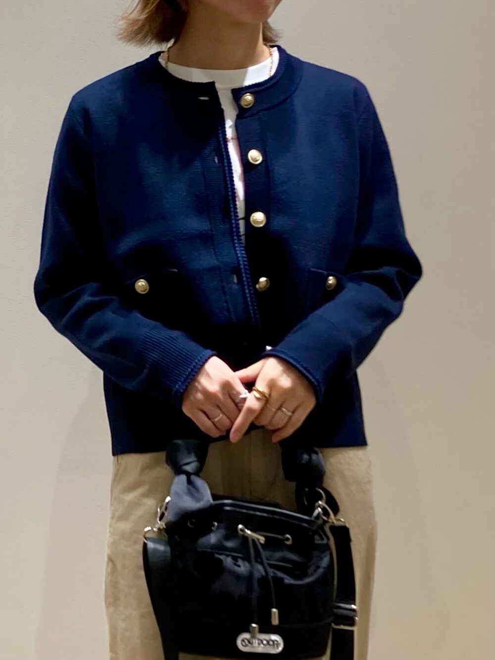 ブラック系のショルダーバッグ、ブルー系のカーディガン/ボレロ、ホワイト系のTシャツ/カットソーを着用したレディースの秋コーディネートの8枚目の写真