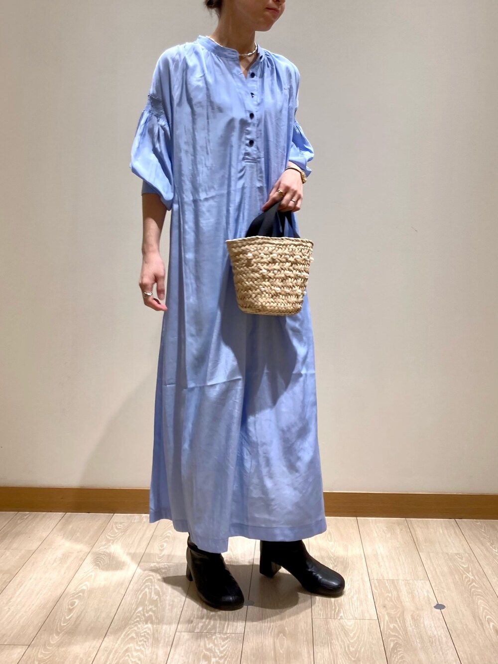 ブルー系のワンピース、ホワイト系のトートバッグ、ゴールド系のネックレスを着用したレディースの春コーディネートの3枚目の写真