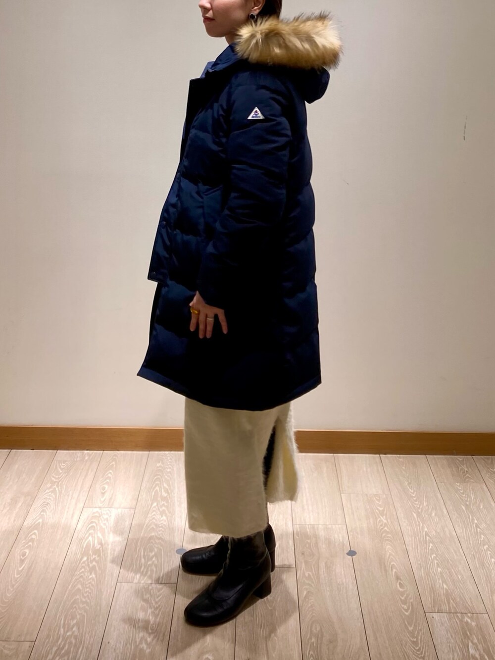 ブルー系のダウンジャケット/コート、ホワイト系のスカート、グレー系のスウェットを着用したレディースの冬コーディネートの5枚目の写真