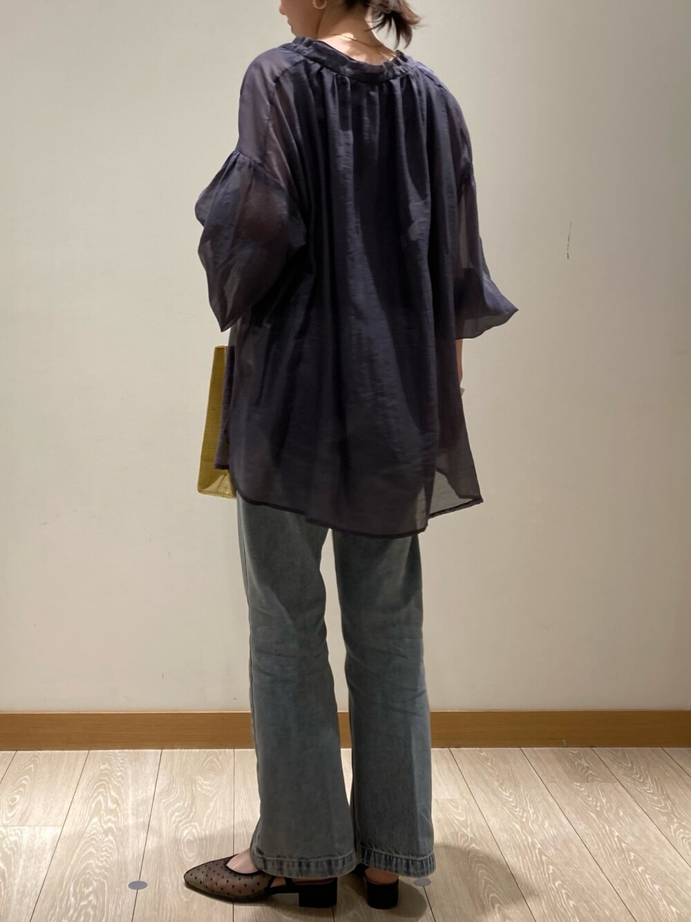 イエロー系のかごバッグ、ブルー系のデニムパンツ、ブラック系のパンプスを着用したレディースの春コーディネートの6枚目の写真