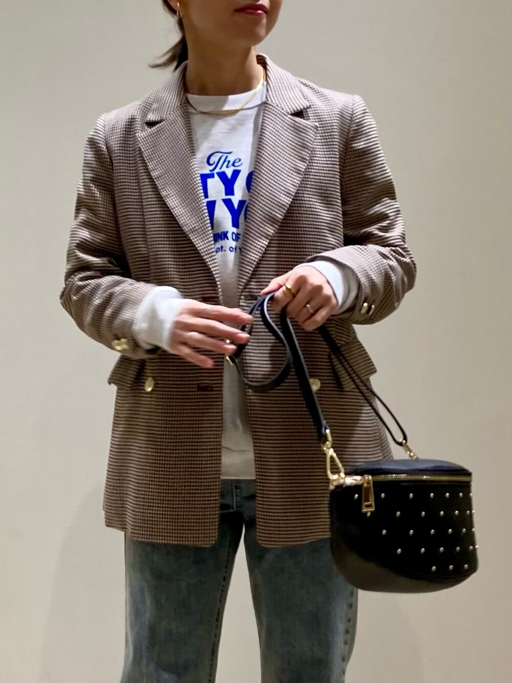 ブラック系のショルダーバッグ、ブルー系のデニムパンツ、シルバー系のバレエシューズを着用したレディースの冬コーディネートの4枚目の写真