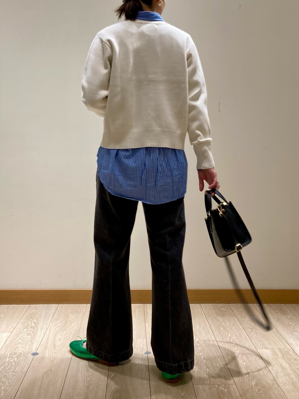 グリーン系のバレエシューズ、ブラック系のトートバッグ、ブラック系のデニムパンツを着用したレディースの冬コーディネートの6枚目の写真