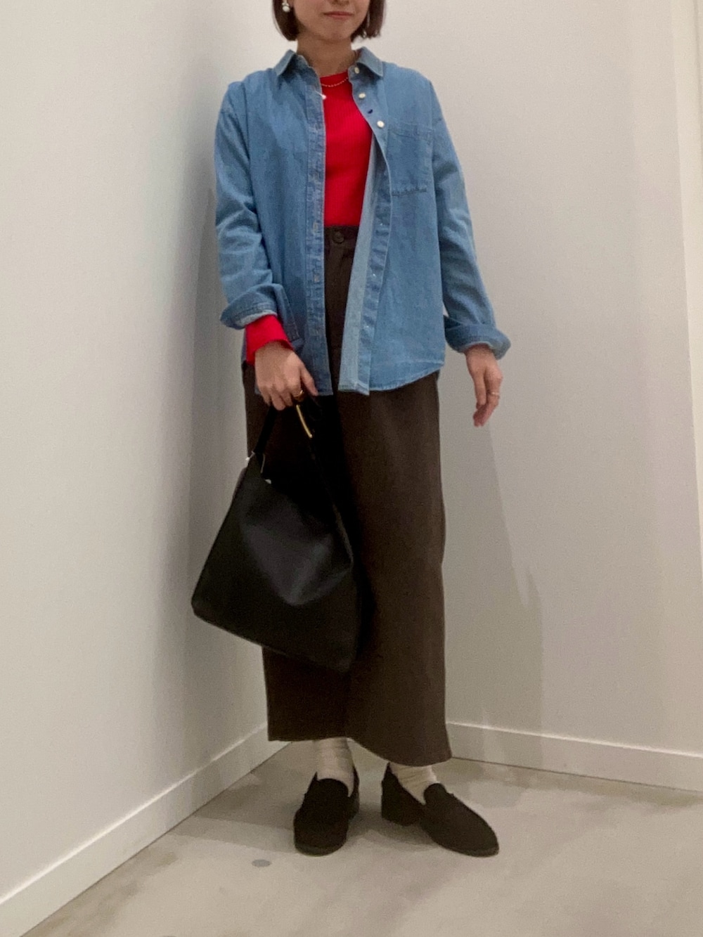 レッド系のニット/セーター、ブルー系のシャツ/ブラウス、ブラウン系のスカートを着用したレディースの冬コーディネートの7枚目の写真