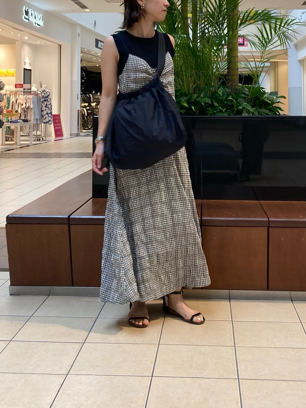 ブラック系のワンピース、ブラック系のショルダーバッグ、ブラック系のサンダルを着用したレディースの夏コーディネートの2枚目の写真