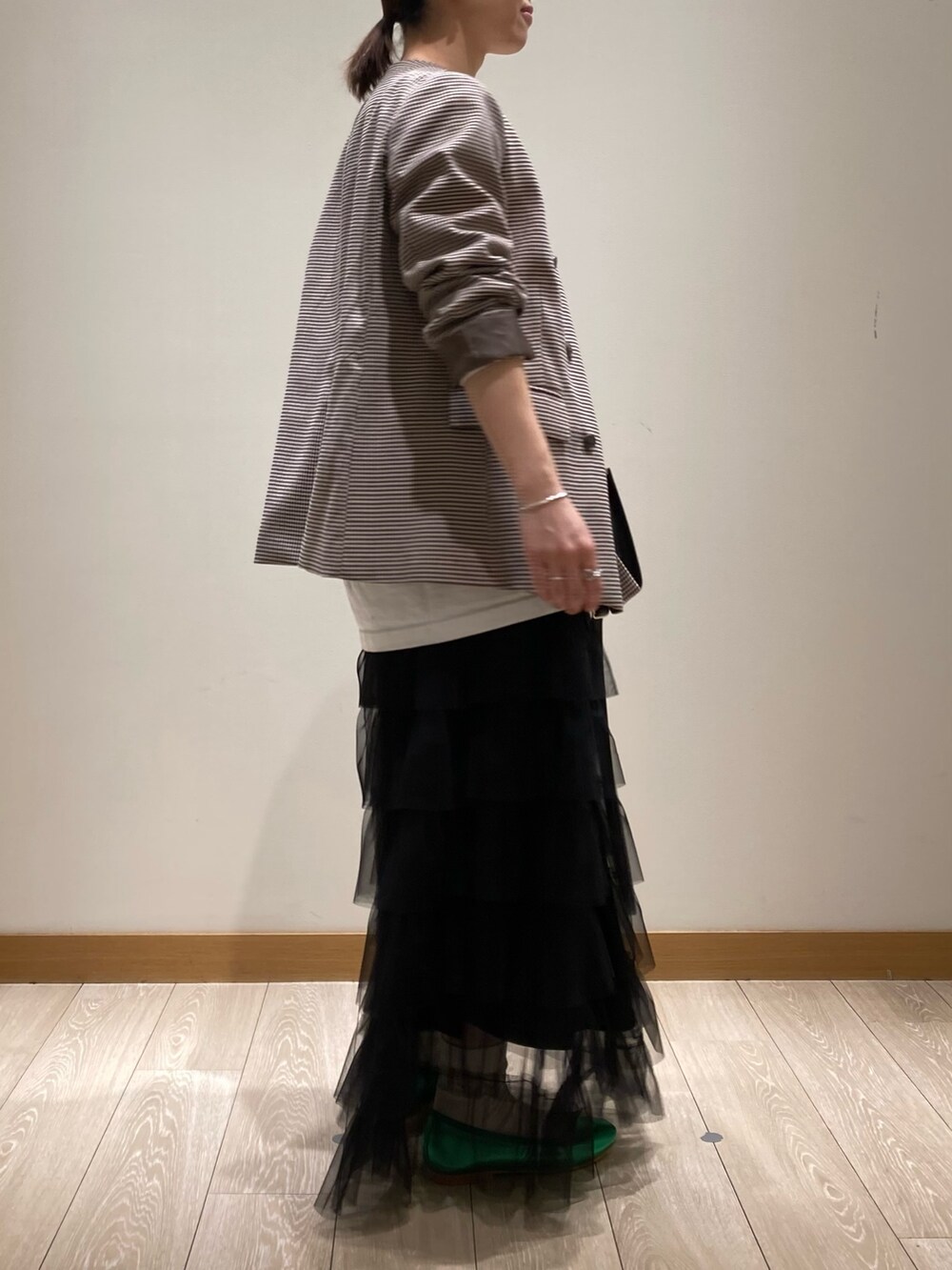 ブラック系のトートバッグ、ブラック系のスカート、グリーン系のバレエシューズを着用したレディースの春コーディネートの6枚目の写真