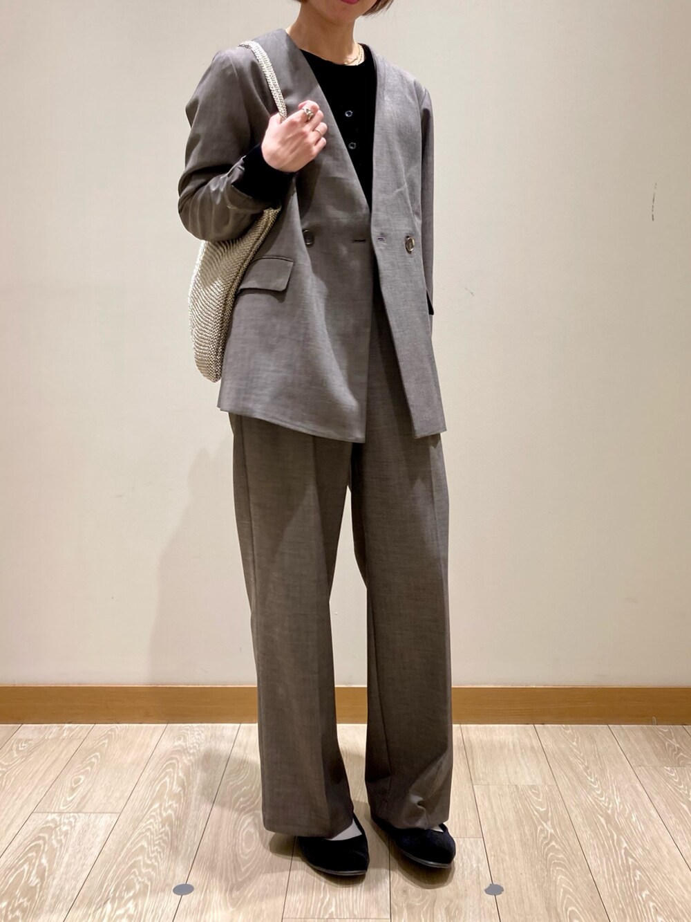 グレー系のノーカラージャケット、グレー系のスラックス、ブラック系のTシャツ/カットソーを着用したレディースの秋コーディネートの3枚目の写真