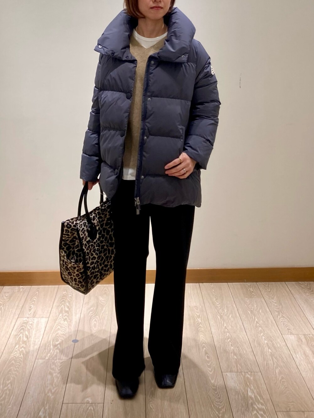 ブラック系のその他パンツ、グレー系のダウンジャケット/コート、イエロー系のニット/セーターを着用したレディースの冬コーディネートの2枚目の写真