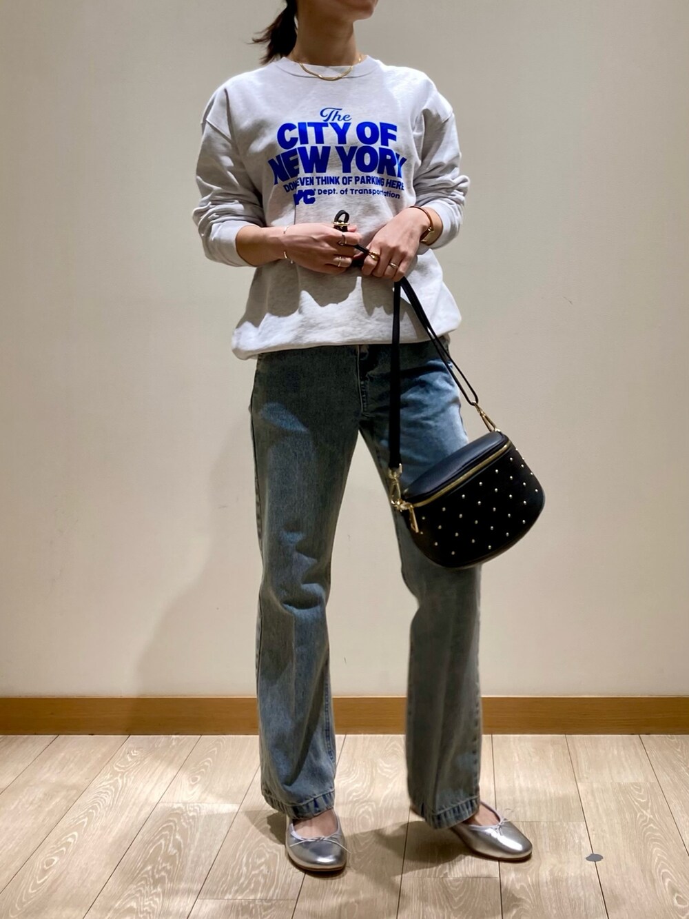 ブルー系のデニムパンツ、ブラック系のショルダーバッグ、シルバー系のバレエシューズを着用したレディースの冬コーディネートの5枚目の写真