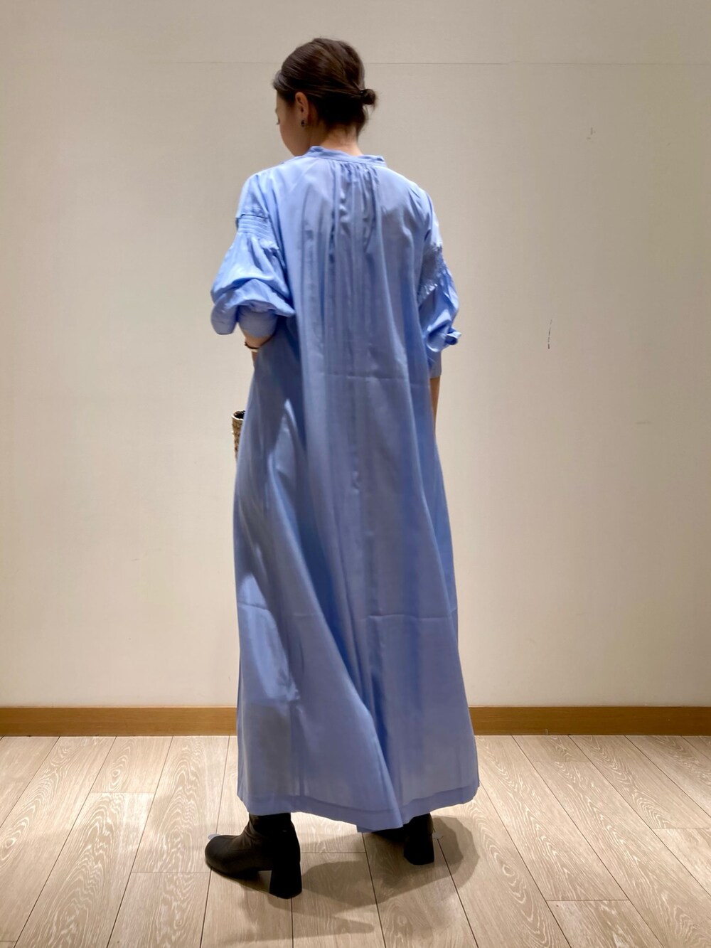 ブルー系のワンピース、ホワイト系のトートバッグ、ゴールド系のネックレスを着用したレディースの春コーディネートの6枚目の写真