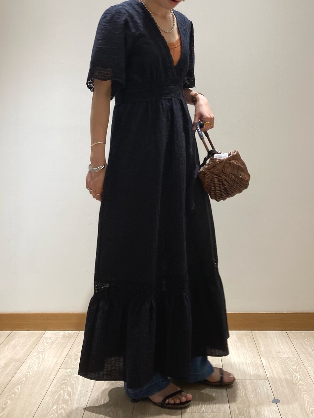 ブルー系のデニムパンツ、ブラック系のサンダル、ブラック系のワンピースを着用したレディースの夏コーディネートの2枚目の写真