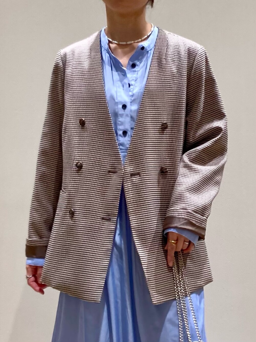 シルバー系のショルダーバッグ、ブルー系のワンピース、ベージュ系のノーカラージャケットを着用したレディースの春コーディネートの8枚目の写真