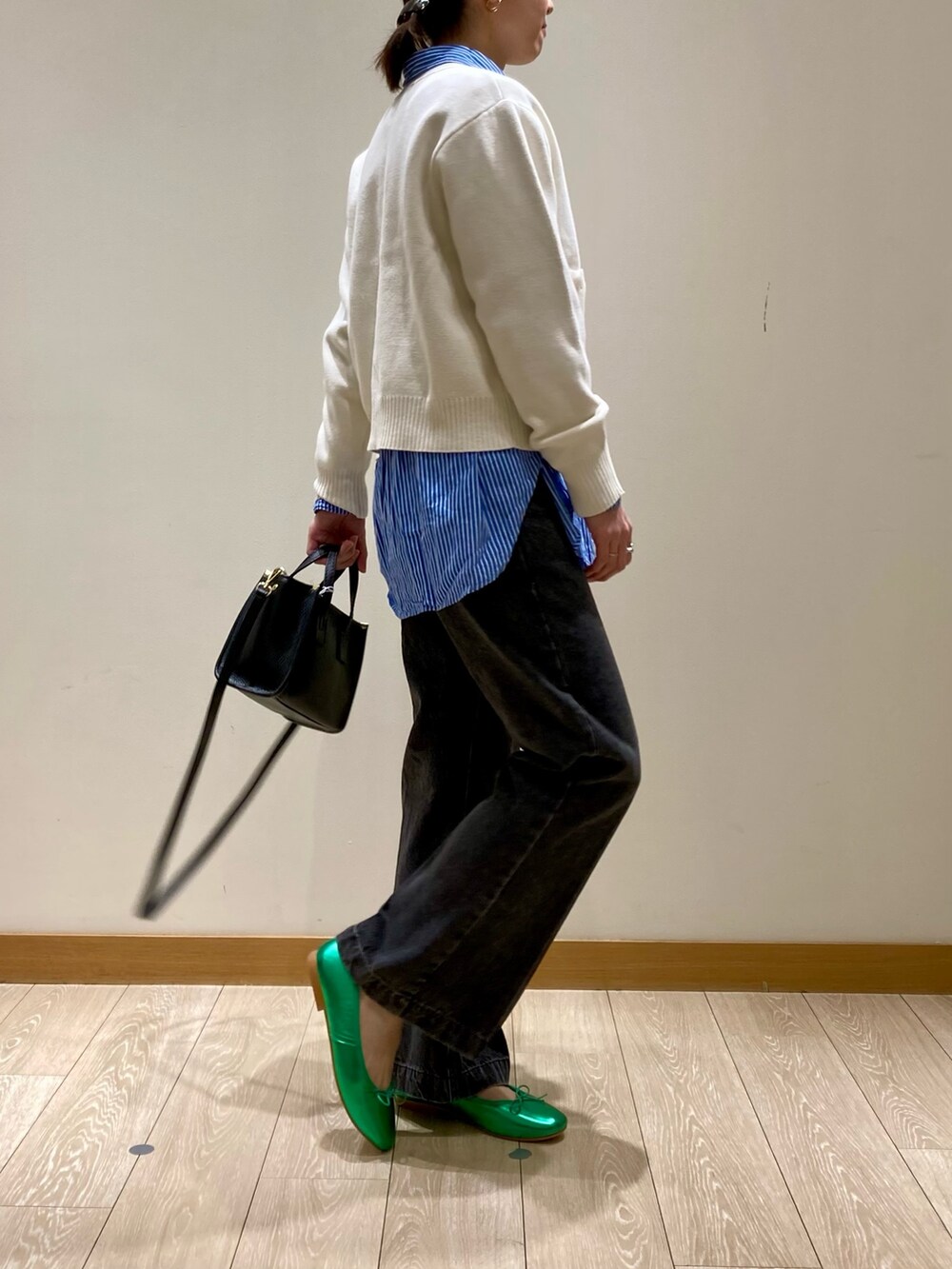 グリーン系のバレエシューズ、ブラック系のトートバッグ、ブラック系のデニムパンツを着用したレディースの冬コーディネートの3枚目の写真