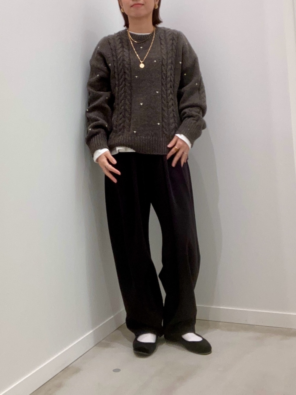 グレー系のニット/セーター、ホワイト系のTシャツ/カットソー、ブラック系のその他パンツを着用したレディースの秋コーディネートの7枚目の写真