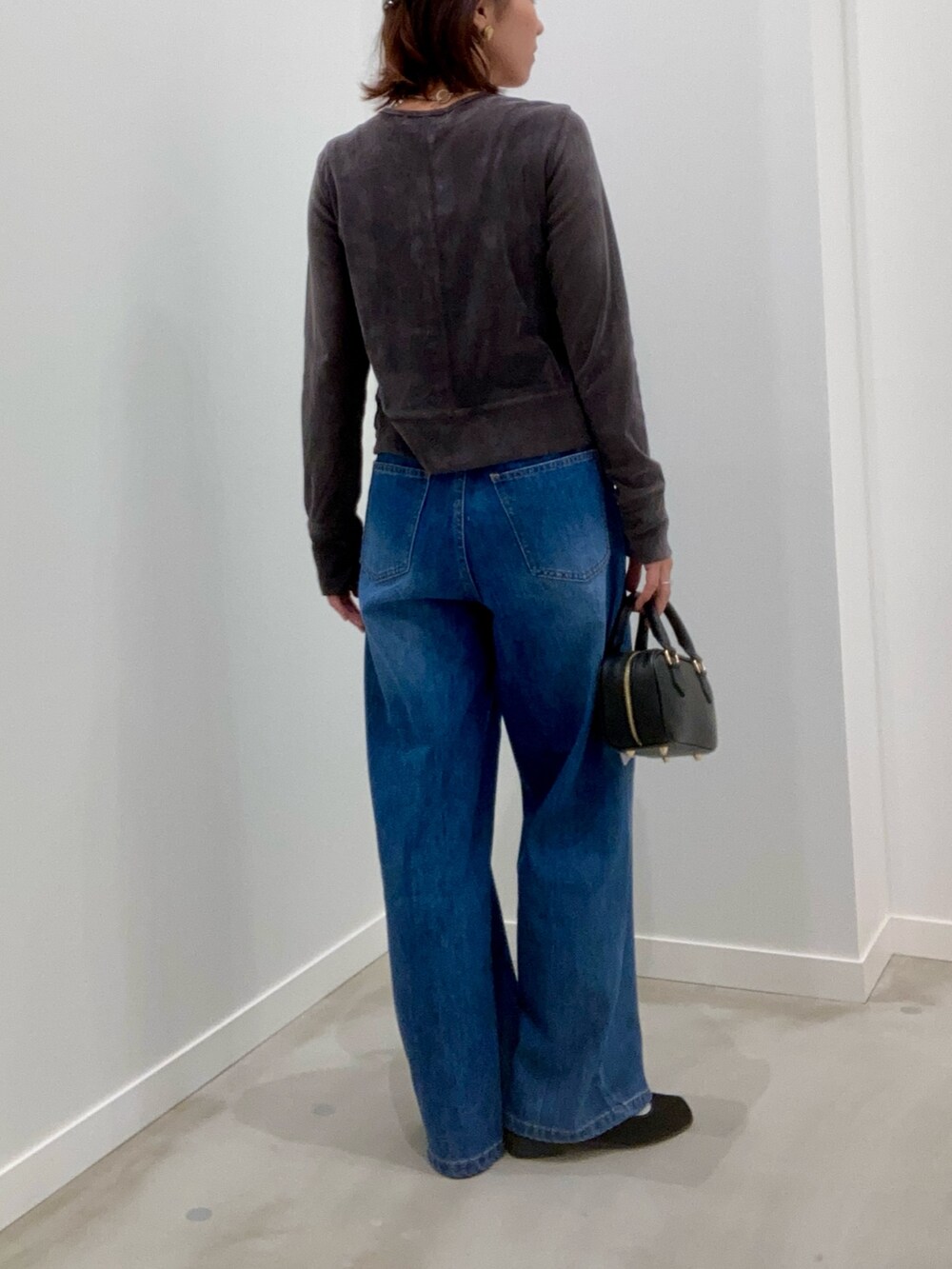グレー系のカーディガン/ボレロ、ブルー系のデニムパンツ、ブラック系のショルダーバッグを着用したレディースの秋コーディネートの5枚目の写真