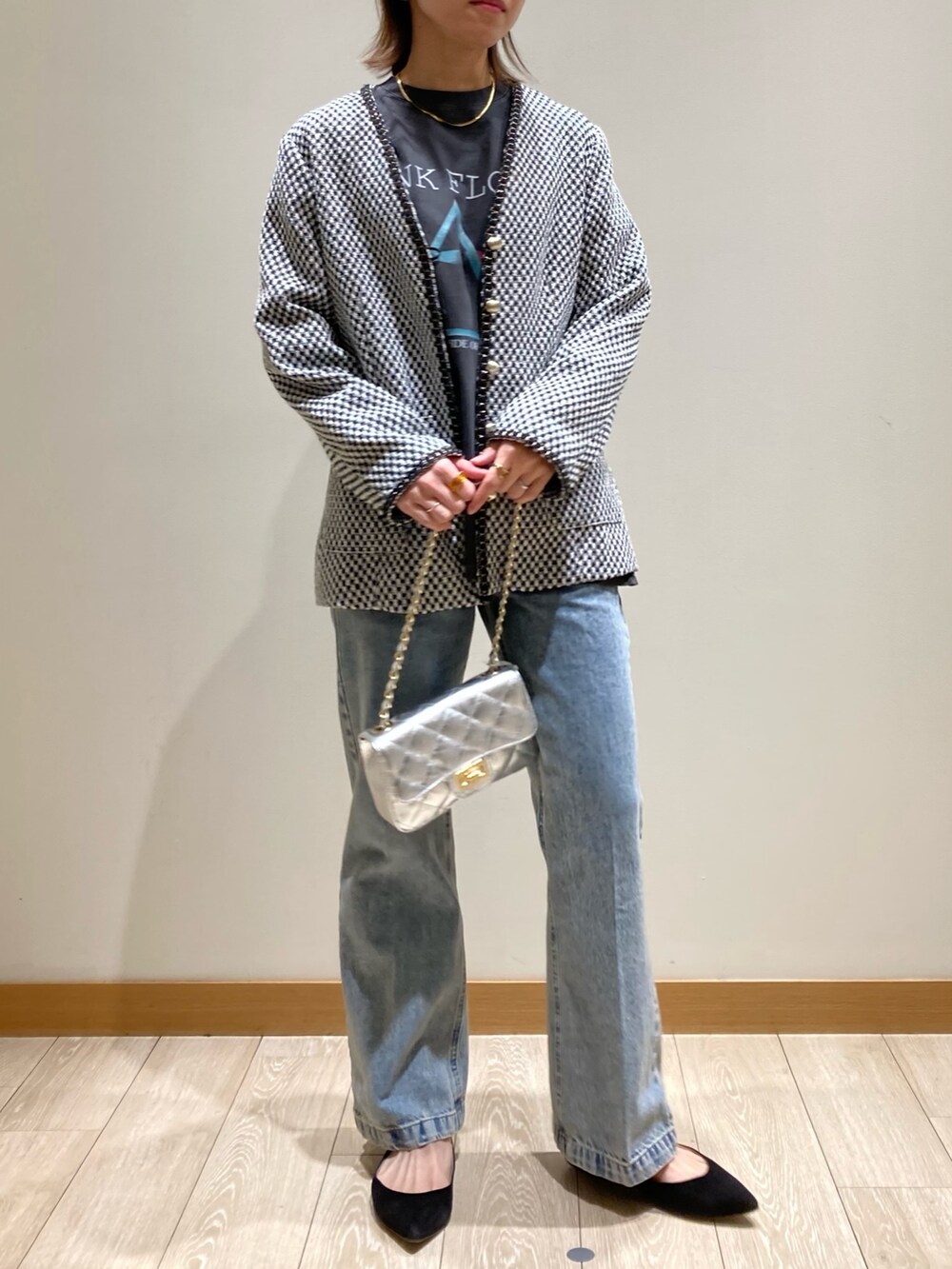 ブルー系のデニムパンツ、シルバー系のショルダーバッグ、ブラック系のノーカラージャケットを着用したレディースの冬コーディネートの6枚目の写真