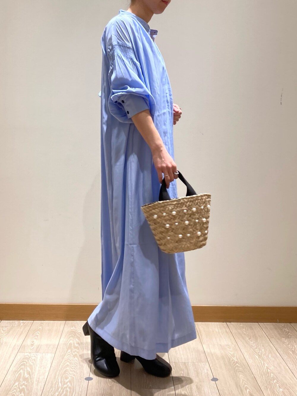 ブルー系のワンピース、ホワイト系のトートバッグ、ゴールド系のネックレスを着用したレディースの春コーディネートの5枚目の写真